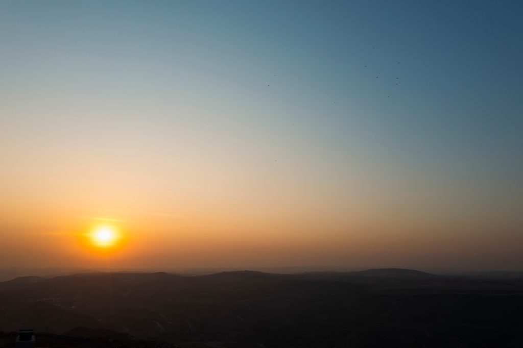 beautiful foggy landscape with mountains peak and sunset sky